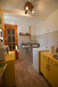 a kitchen with yellow and white cabinets and a ceiling at Kerti lak in Mór