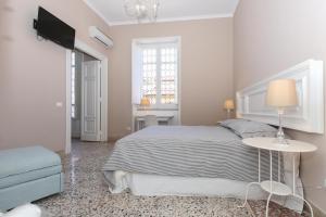 sypialnia z łóżkiem, stołem i telewizorem w obiekcie Le case d'un tempo w mieście Palermo