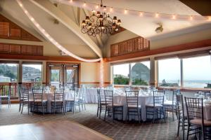 einen Bankettsaal mit Tischen, Stühlen und Fenstern in der Unterkunft Surfsand Resort in Cannon Beach