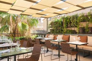 un restaurante con mesas, sillas y plantas en Hotel Antigua Palma - Casa Noble, en Palma de Mallorca