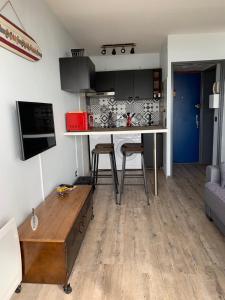 a living room with a kitchen and a table at LACANAU FRONT DE MER in Lacanau