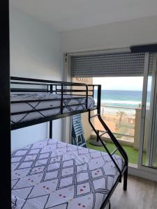 a bedroom with a bunk bed with a view of the beach at LACANAU FRONT DE MER in Lacanau