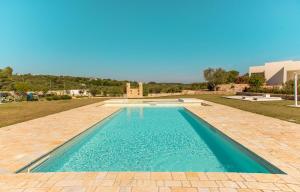 a swimming pool in the middle of a grassy field at Tenuta Ermes in Ostuni