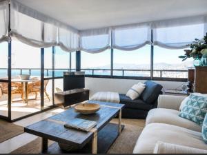salon z kanapą i stołem w obiekcie ATICO BENIDORM PLANTA 25 w mieście Benidorm