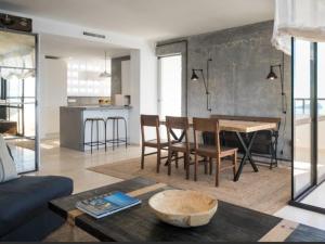 sala de estar con mesa y cocina en ATICO BENIDORM PLANTA 25 en Benidorm