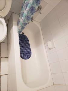 a bathroom with a toilet and a blue shower curtain at Miami Cheapest Place in Miami