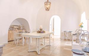 a white dining room with a white table and chairs at Tenuta Ermes in Ostuni