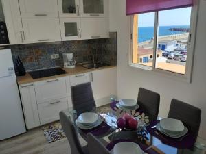 a kitchen and dining room with a table and chairs at VISTAMAR VISTALUNA in Corralejo