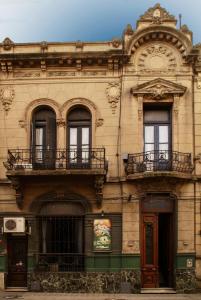 an old building with two balconies on top of it at Hostel La Casona de Don Jaime 2 and Suites HI in Rosario
