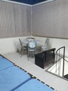 a patio with a table and chairs in a room at Sótão Oktoberfest in Blumenau