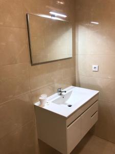 a bathroom with a white sink and a mirror at Marqueses de Ferreira in Lamas de Ferreira