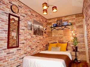 2 camas en una habitación con una pared de ladrillo en West Taisho, en Osaka
