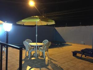 a table with chairs and a yellow umbrella at Visk Palace Hotel e Restaurante in Foz do Iguaçu