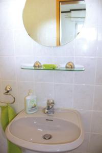 a white bathroom with a sink and a mirror at Wolfs Ferienhaus - Natürlich Eifel in Blankenheim