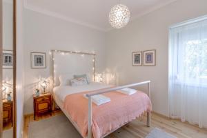 biała sypialnia z łóżkiem i oknem w obiekcie Sunny, Bright and Quiet Apartment, By TimeCooler w Lizbonie