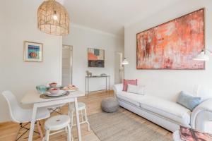 uma sala de estar com um sofá branco e uma mesa em Sunny, Bright and Quiet Apartment, By TimeCooler em Lisboa