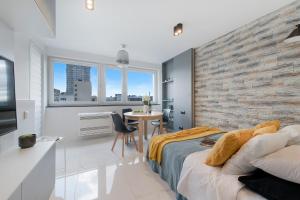 a bedroom with a brick wall and a bed and a table at P&O Apartments Zgoda in Warsaw