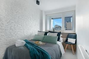 sypialnia z łóżkiem i oknem w obiekcie P&O Apartments Zgoda w Warszawie