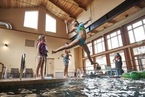 uma rapariga a saltar para uma piscina em Surfsand Resort em Cannon Beach