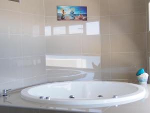 a white tub in a bathroom with a mirror at Departamento La Serena in Coquimbo