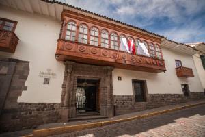 a building with a balcony with flags on it at Aranwa Cusco Boutique Hotel in Cusco