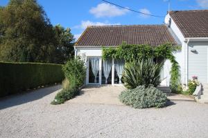 una casa blanca con una valla y un patio en La Roseraie, en Yvetot Bocage