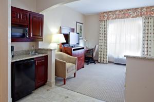 Habitación de hotel con cocina y sala de estar. en Holiday Inn Express & Suites College Station, an IHG Hotel en College Station