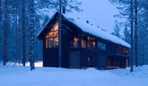uma cabana de madeira na floresta na neve em Levi Spirit Luxury Villas & Resort em Levi