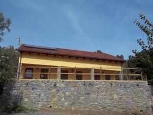 una casa con un muro di pietra di fronte di Agriturismo Rio Castello a Marina dʼAndora