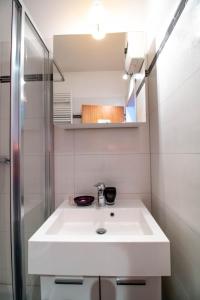 une salle de bain avec un lavabo blanc et une douche dans l'établissement Wohnung im Herzen der Turracher Höhe, à Brandstätter