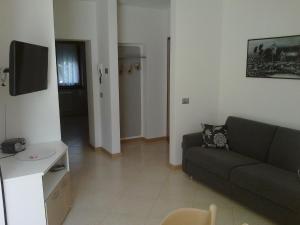 a living room with a couch and a tv at Casa Ferrari Monica CIPAT 22032 in Calceranica al Lago