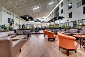 un restaurante con sofás, mesas y sillas en The Atrium Hotel on Third, en Quincy