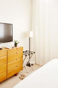 a bedroom with a tv and a dresser with a bed at Palm Heights in George Town