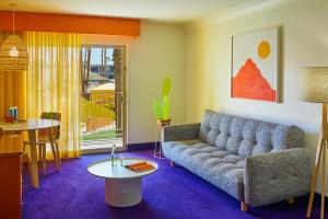 a living room with a couch and a table at The Saguaro Palm Springs in Palm Springs