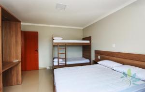 1 dormitorio con cama, escalera y literas en Residencial Bela Morada en Torres