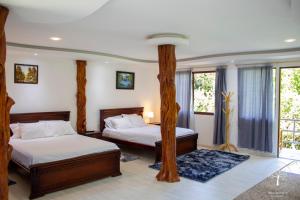 a bedroom with two beds and a large window at Brisas del Paraiso in Manglaralto