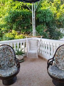two chairs and a hammock on a porch at Casa Hotel Manga Mar in Cartagena de Indias