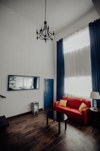 a living room with a red couch and blue curtains at Trojan House in Ensenada