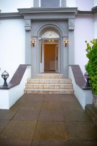 un edificio blanco con escaleras que conducen a una puerta en Carmel House, en Llandudno