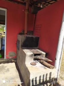 an old brick oven sitting next to a red wall at Pouso do Elefante in Serra do Cipo