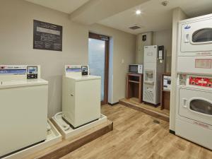 uma lavandaria com máquinas de lavar e secar roupa em exposição em HOTEL MYSTAYS Kiyosumi Shirakawa em Tóquio