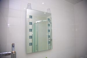 a mirror on a wall in a bathroom at Carmel House in Llandudno