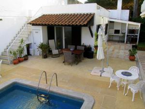 eine Terrasse mit Pool und Tisch und ein Haus in der Unterkunft Go PT - Private challet with swimming pool and garden in Parede