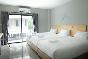 um quarto com 2 camas e uma grande janela em Fine Bed Hotel em Nonthaburi