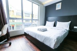 a bedroom with a large bed with a large window at Hotel 99 Bandar Klang (Meru) in Klang