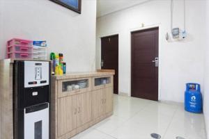 a kitchen with a counter with a microwave and a refrigerator at RedDoorz Plus near Lippo Cikarang Mall in Bekasi