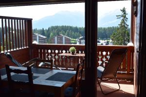 d'une table et de chaises sur un balcon avec vue sur les montagnes. dans l'établissement Superbe studio à Crans-Montana, à Crans-Montana