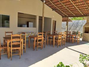 Villa Portal dos Ventos في فورتيم: مجموعة من الطاولات والكراسي على الفناء