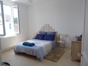 a bedroom with a large bed with blue pillows at Le Pouliguen tout à pied - Grand appart lumineux - Ménage et linge non compris in Le Pouliguen