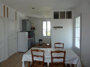 a kitchen with a table and chairs in a room at Le Pouliguen tout à pied - Grand appart lumineux - Ménage et linge non compris in Le Pouliguen